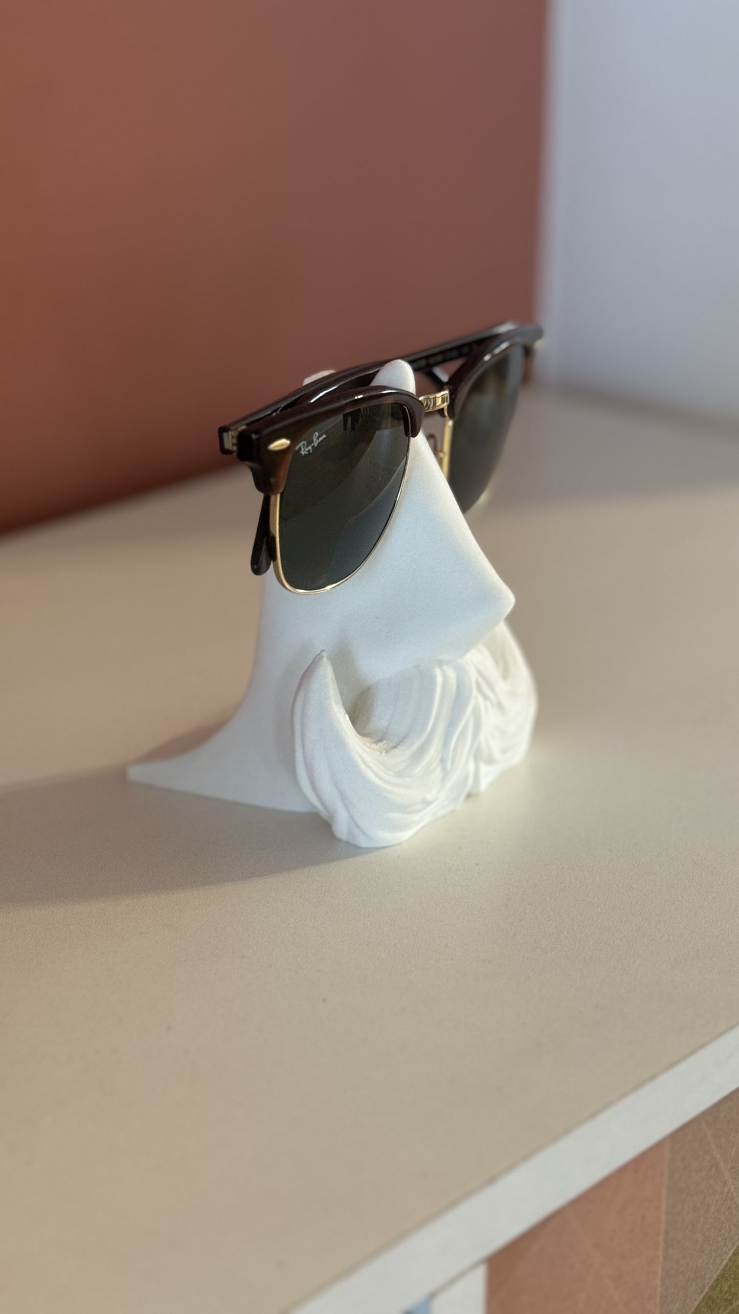 Glasses placed on the Distinguished Gentleman Glasses Stand, illustrating how it securely holds eyewear with a touch of sophistication.