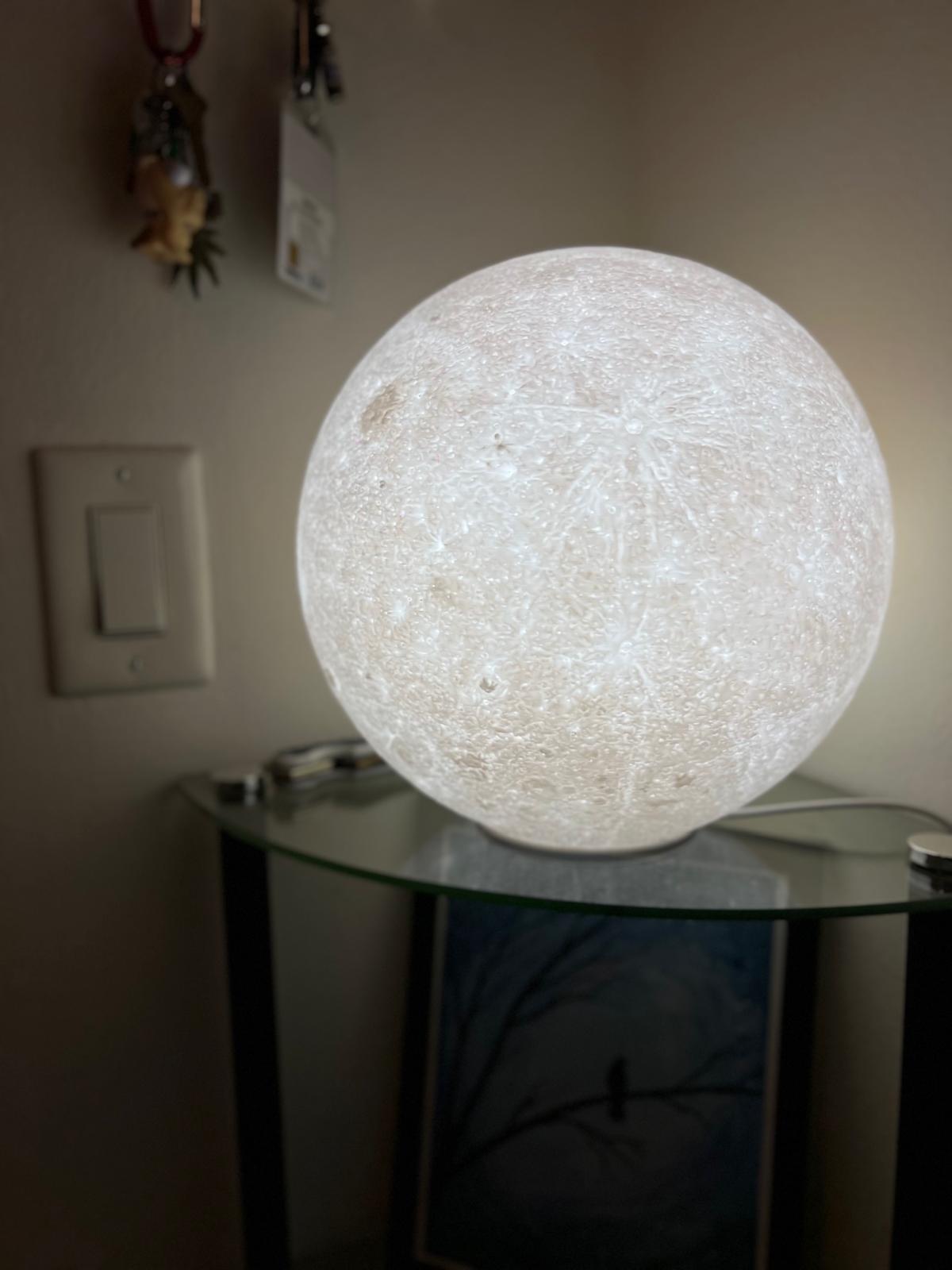 stunning 3D lunar lamp illuminated to reveal a highly detailed surface, showcasing realistic craters and textures.