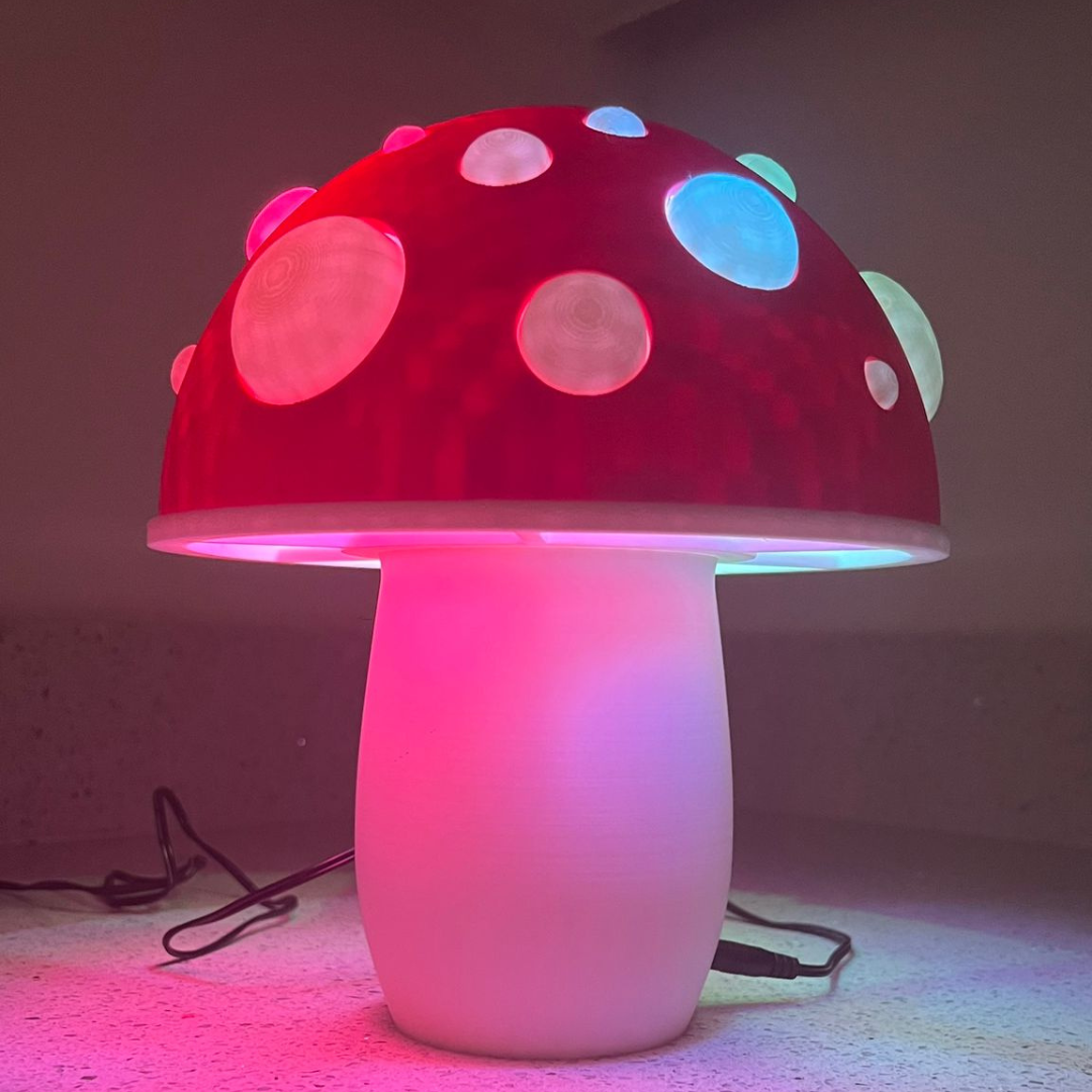 A charming 3D-printed mushroom lamp with a red cap and glowing LED lights in various colors, creating a magical ambiance.