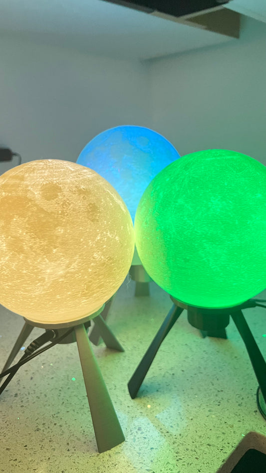 A variety of mini moon lamps illuminated in different colors, including white, green, blue, and pink, showcasing detailed moon textures.